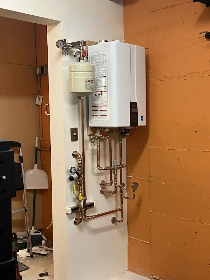 Plumbing technician inspecting water heater connections in South Bay